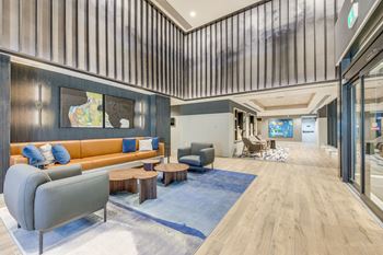 A modern living room with a grey sofa and a wooden floor.